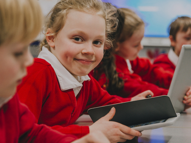 Young primary school pupils using tablets in a classroom