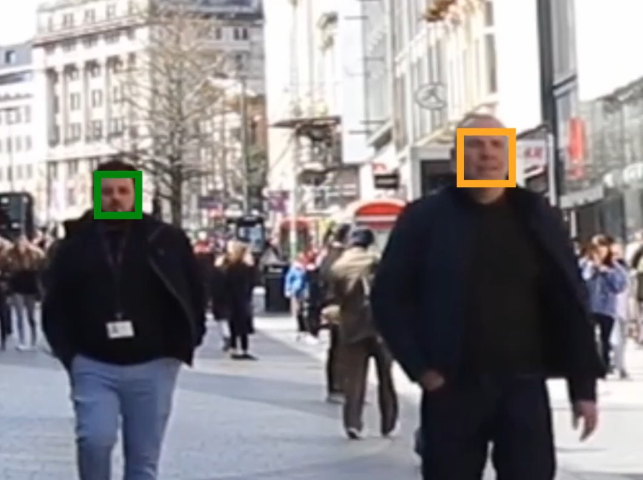 Two people walking along a crowded street, their faces highlighted by coloured rectangles